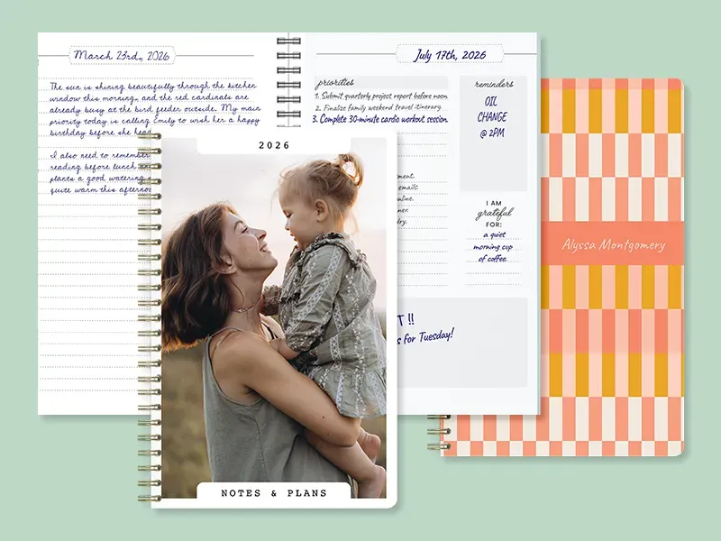 Three personalized spiral notebooks: a 2026 'Notes & Plans' journal with a mother-and-daughter photo cover open to handwritten dated entries, and a coral-and-orange checkered notebook personalized with the name 'Alyssa Montgomery.'